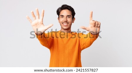 hispanic handsome man smiling and looking friendly, showing number seven or seventh with hand forward, counting down