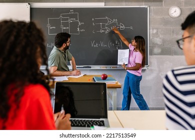 Hispanic Latin Young Adult Female Student Explaining Technology Project To Multiracial Group Of Classmate Friends During Academic Presentation At High School - Education Concept