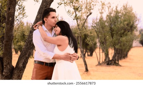 Hispanic Latino couple having a romantic moment in a dry autumn field of olive trees - Powered by Shutterstock