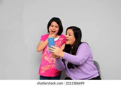 Hispanic Latino Mom And Daughter Play, Dance, Surprise, Enjoy, Taking Selfies Using The Cell Phone Spending Quality Family Time