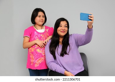 Hispanic Latino Mom And Daughter Play, Dance, Surprise, Enjoy, Taking Selfies Using The Cell Phone Spending Quality Family Time