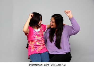 Hispanic Latino Mom And Daughter Play, Dance, Surprise, Enjoy, Taking Selfies Using The Cell Phone Spending Quality Family Time