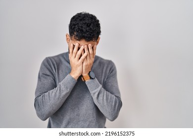 Hispanic man with beard standing over white background with sad expression covering face with hands while crying. depression concept.  - Powered by Shutterstock