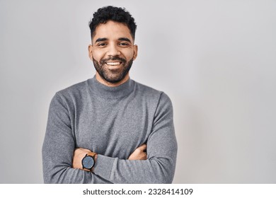Hispanic man with beard standing over white background happy face smiling with crossed arms looking at the camera. positive person.  - Shutterstock ID 2328414109
