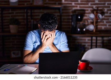 Hispanic Man With Beard Using Laptop At Night With Sad Expression Covering Face With Hands While Crying. Depression Concept. 