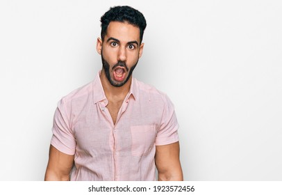 Hispanic Man With Beard Wearing Casual Shirt Afraid And Shocked With Surprise Expression, Fear And Excited Face. 