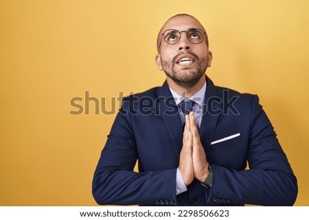 Hispanic man with beard wearing suit and tie begging and praying with hands together with hope expression on face very emotional and worried. begging.  Foto d'archivio © 