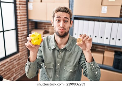 Hispanic Man With Beard Working At Small Business Ecommerce Holding Piggy Bank And Bitcoin Looking At The Camera Blowing A Kiss Being Lovely And Sexy. Love Expression. 