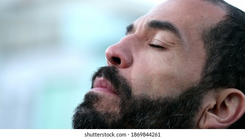 Hispanic man closing eyes in meditation. 40 year old person eyes closed being mindful