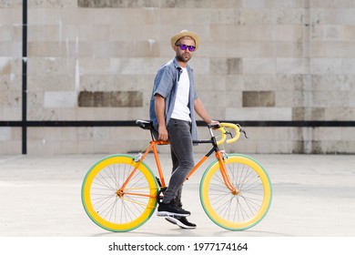 Hispanic man with a colorful fixie  bike. Urban ecologic and sustainable mobility concept.