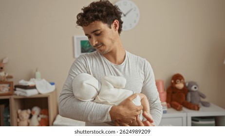 Hispanic man cradling sleeping baby in cozy bedroom surrounded by soft toys and neutral decor creating a warm nurturing family atmosphere indoors