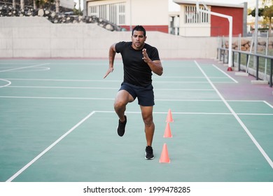 Hispanic Man Doing Speed And Agility Cone Drills Workout Session Outdoors - Focus On Man Face