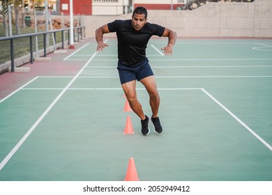 Hispanic Man Doing Speed And Agility Cone Drills Workout Session Outdoors - Focus On Man Face