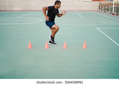 Hispanic Man Doing Speed And Agility Cone Drills Workout Session Outdoors - Focus On Man Face