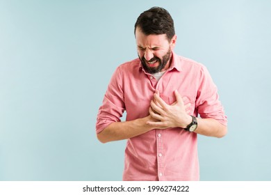 Hispanic man in his 30s having a heart attack and suffering from chest pain. Middle age man with a cardiovascular disease  - Shutterstock ID 1996274222