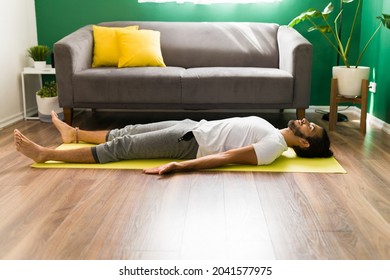 Hispanic Man With His Eyes Closed Doing Breathing Exercises And Relaxing While Practicing Savasana 