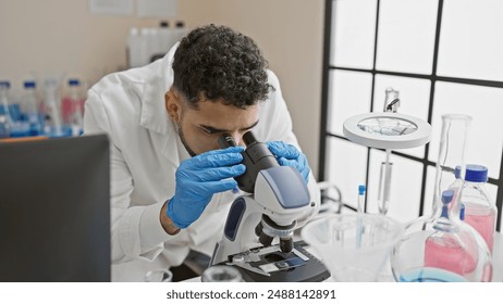 Hispanic man in lab coat using microscope in a laboratory - Powered by Shutterstock