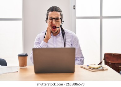 Hispanic Man With Long Hair Working Using Computer Laptop Clueless And Confused With Open Arms, No Idea And Doubtful Face. 