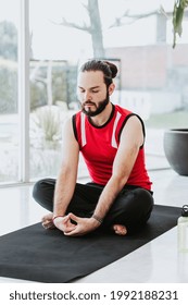 Hispanic Man Meditating With Eyes Closed And Breathing Slowly At Home In Latin America