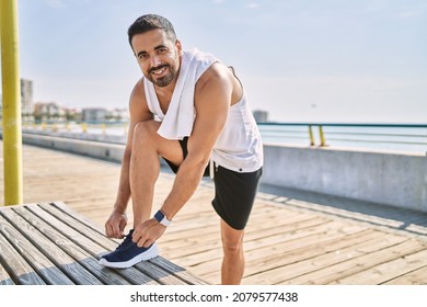 Hispanic Man Working Out Outdoors On A Sunny Day Tying His Laces