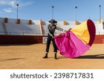 Hispanic matador dancing on sandy arena