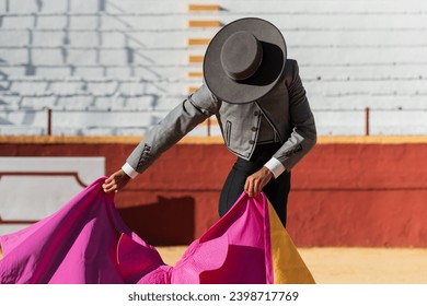 Hispanic matador dancing on sandy arena