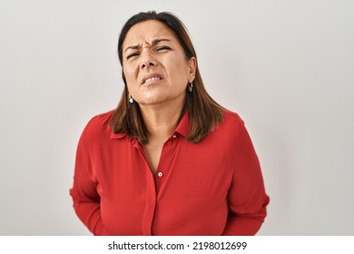 Hispanic Mature Woman Standing Over White Background With Hand On Stomach Because Indigestion, Painful Illness Feeling Unwell. Ache Concept. 