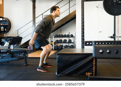 Hispanic middle-aged athlete executing box jumps, displaying intense focus during high-intensity strength workout in contemporary fitness facility - Powered by Shutterstock - Get 15% off with code: PIKWIZARD15