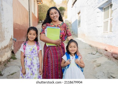 Hispanic Mom And Daughters Ready To Go To School - Latin Mom Accompanying Her Daughters To School - Hispanic Girls With Backpack Outside Their House In Rural Area