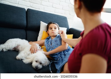 Hispanic Mom Measuring Fever To Sick Daughter With Digital Thermometer. Family Life At Home With Latina Woman Taking Care Of Ill Little Girl. Health Care With Mother And Child, People And Medicine