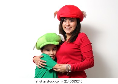 Hispanic mom and son in funny hats play as a family and celebrate their love and friendship with jokes, hugs and games
