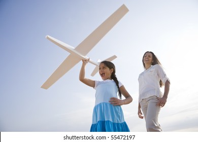 Hispanic Mother And 9 Year Old Child Having Fun With Toy Plane