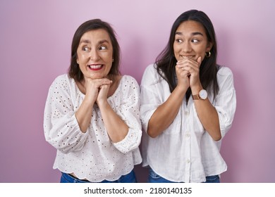 Hispanic Mother And Daughter Together Laughing Nervous And Excited With Hands On Chin Looking To The Side 