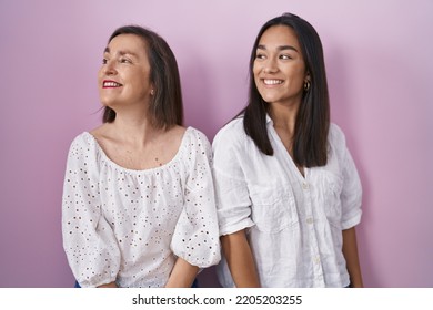 Hispanic Mother And Daughter Together Looking Away To Side With Smile On Face, Natural Expression. Laughing Confident. 