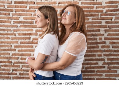 Hispanic Mother And Daughter Wearing Casual White T Shirt Looking To Side, Relax Profile Pose With Natural Face And Confident Smile. 