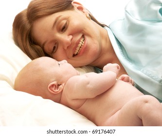 Hispanic Mother Enjoying Her Baby. Mother And New Born Enjoying  In Bed.