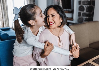 Hispanic Mother Hugging Her Daughter At Cozy Living Room At Home In Mexico Latin America. Family Time