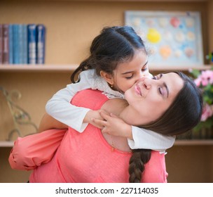Hispanic mother and little daughter playing at home