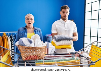 Hispanic Mother And Son Hanging Clothes At Clothesline In Shock Face, Looking Skeptical And Sarcastic, Surprised With Open Mouth 