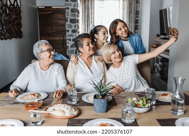 Hispanic Multi Generation Women Family Posing For Photo Selfie At Dinner Time At Home Together In Latin America