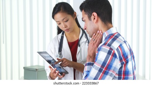 Hispanic Patient Listening To Doctor Talk About X-ray