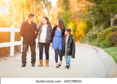 Hispanic Pregnant Family Walking On Path.