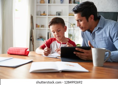 Hispanic pre-teen boy sitting at dining table working with his home school tutor