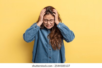 hispanic pretty woman feeling stressed and frustrated, raising hands to head, feeling tired, unhappy and with migraine - Powered by Shutterstock