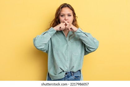 Hispanic Pretty Woman Looking Serious And Displeased With Both Fingers Crossed Up Front In Rejection, Asking For Silence