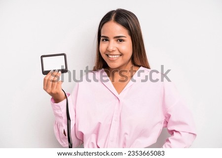 hispanic pretty woman smiling happily with a hand on hip and confident. pass id card concept