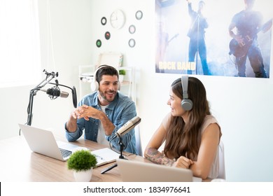 Hispanic radio cohosts wearing headphones and recording a live podcast and sharing their opinions - Powered by Shutterstock