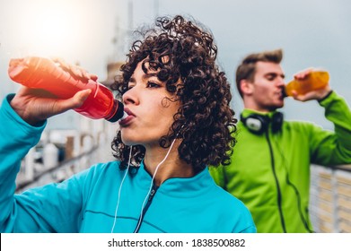 Hispanic runner woman drinking energy drink outdoor 