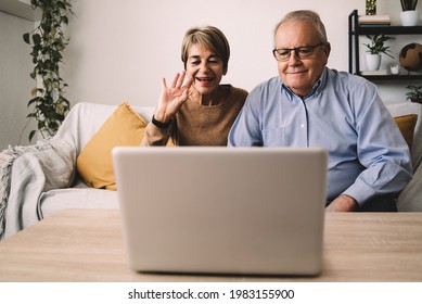 Hispanic Senior Couple Doing Video Call Having Fun With Laptop Computer At Home - Joyful Elderly Lifestyle And Technology Concept - Focus On Faces