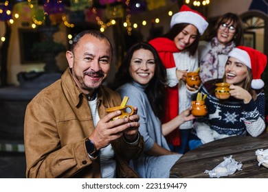 Hispanic senior man portrait holding a cup of fruit punch at traditional posada party for Christmas in Mexico Latin America - Powered by Shutterstock